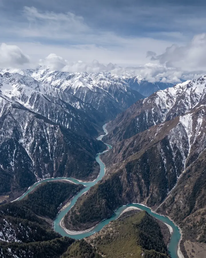 A deep mountain gorge with a river winding through it.