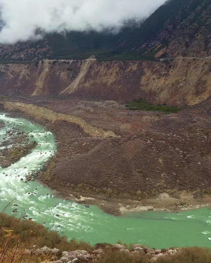 Photo of the Yarlung Tsangpo river in Tibet, with two drawn arrows to scale: a long one labelled Medog, China, about 2 km, and a short one labelled SUMP, about 280 to 300 metres.